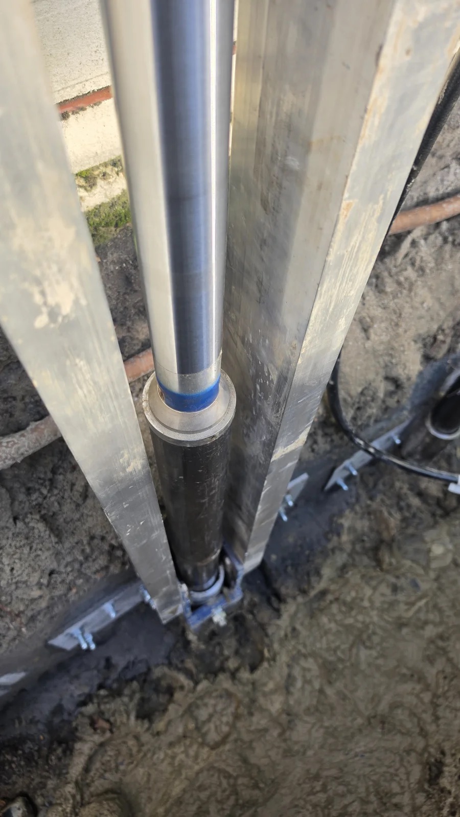 Close-up van een Magnum Push Pier die door de hydraulische vijzel onder de fundering wordt geperst