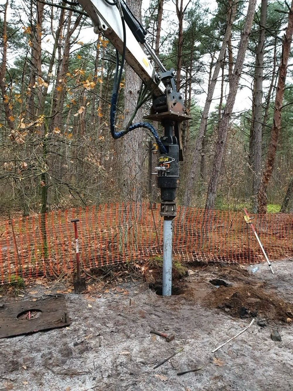 Schroefpaal die in het bos wordt geplaatst voor het verhoogde fietspad