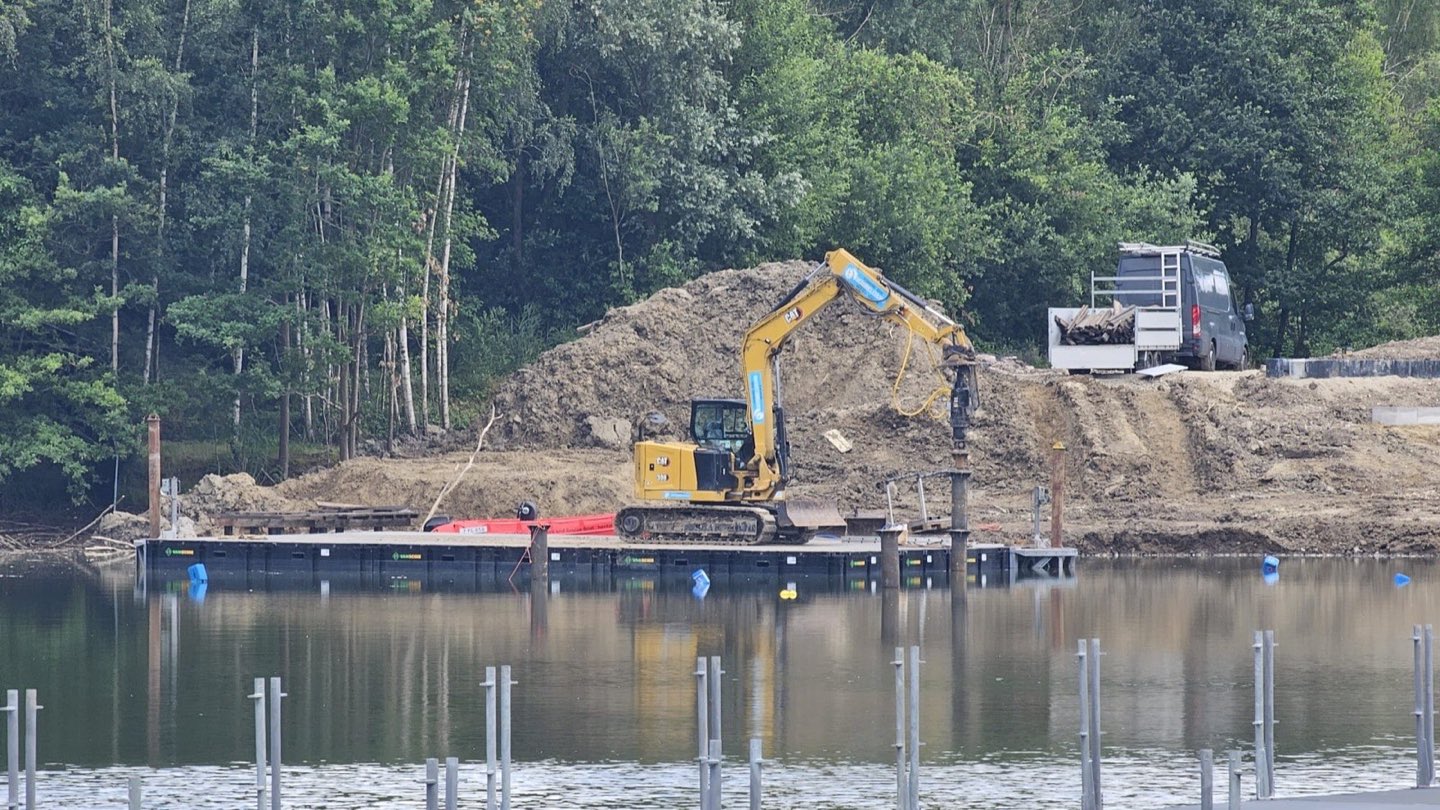 Rijen geplaatste schroefpalen in het water, met het ponton op de achtergrond