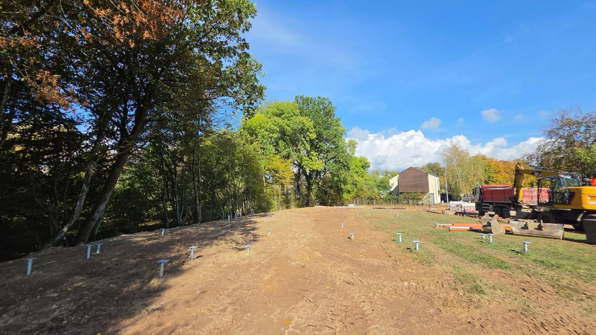 Reihen eingebrachter Schraubpfähle auf einer Baustelle am Waldrand