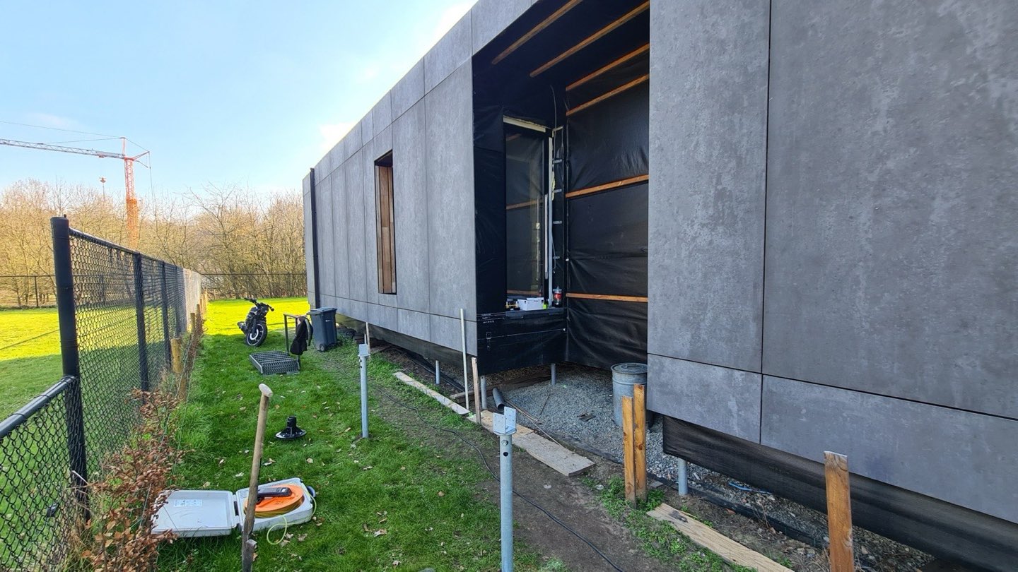 Zijkant van de modulaire woning met zichtbare schroefpalen eronder
