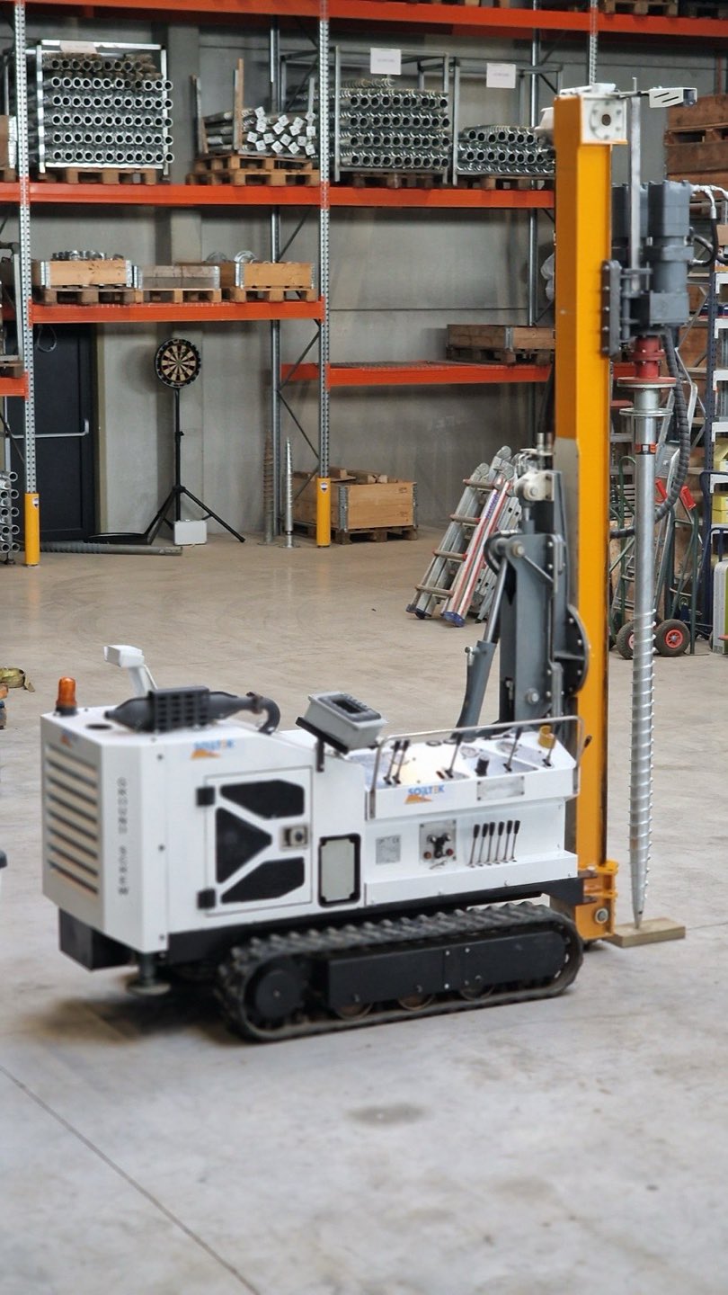 Schroefpaalmachine op rupsen in het magazijn