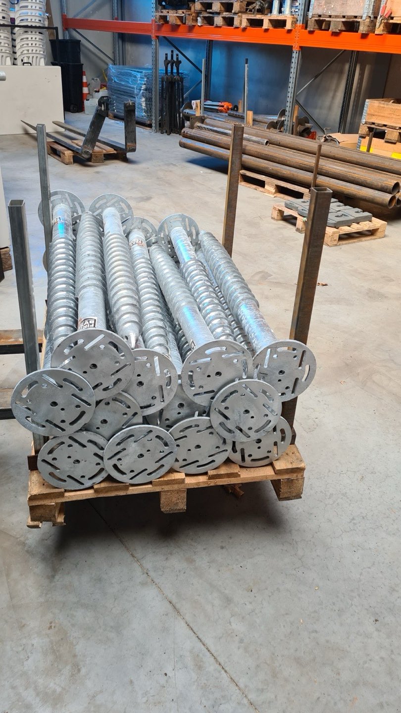 Pallet met verzinkte schroefpalen in het magazijn