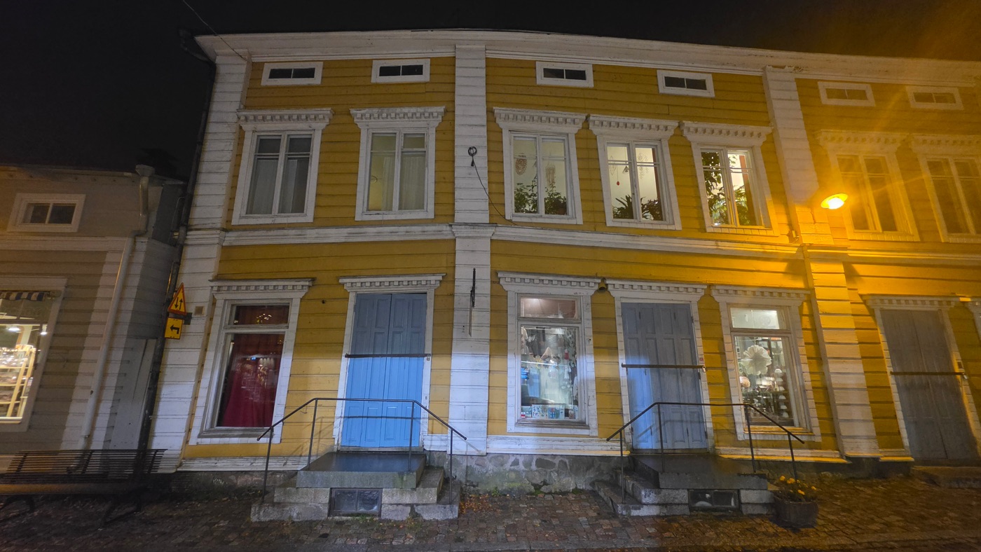 Alte Holzfassade mit schiefen Linien und Fenstern durch eine Setzung